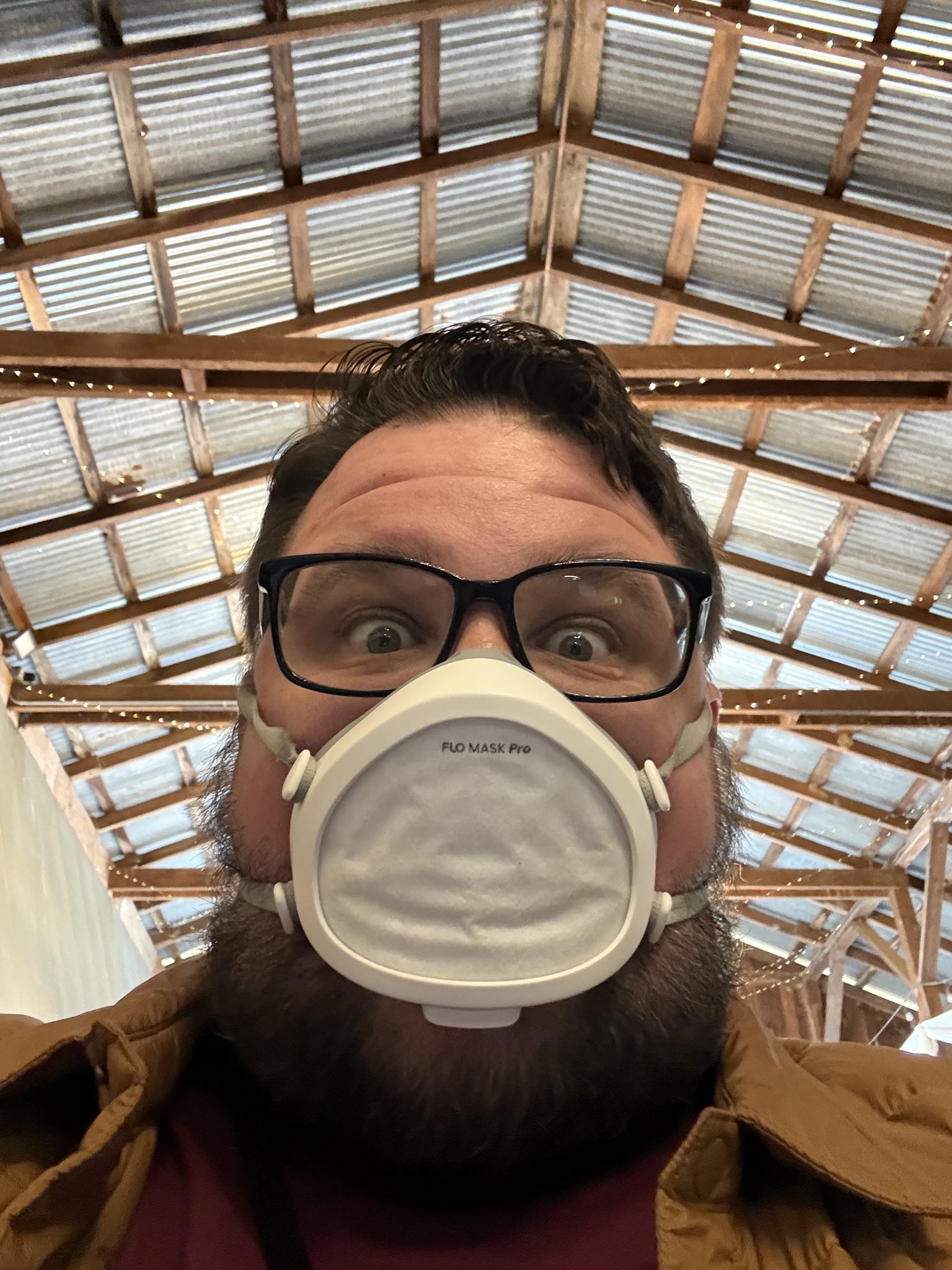 Selfie of my face with a Flo Mask and a slightly unhinged expression, taken in the barn