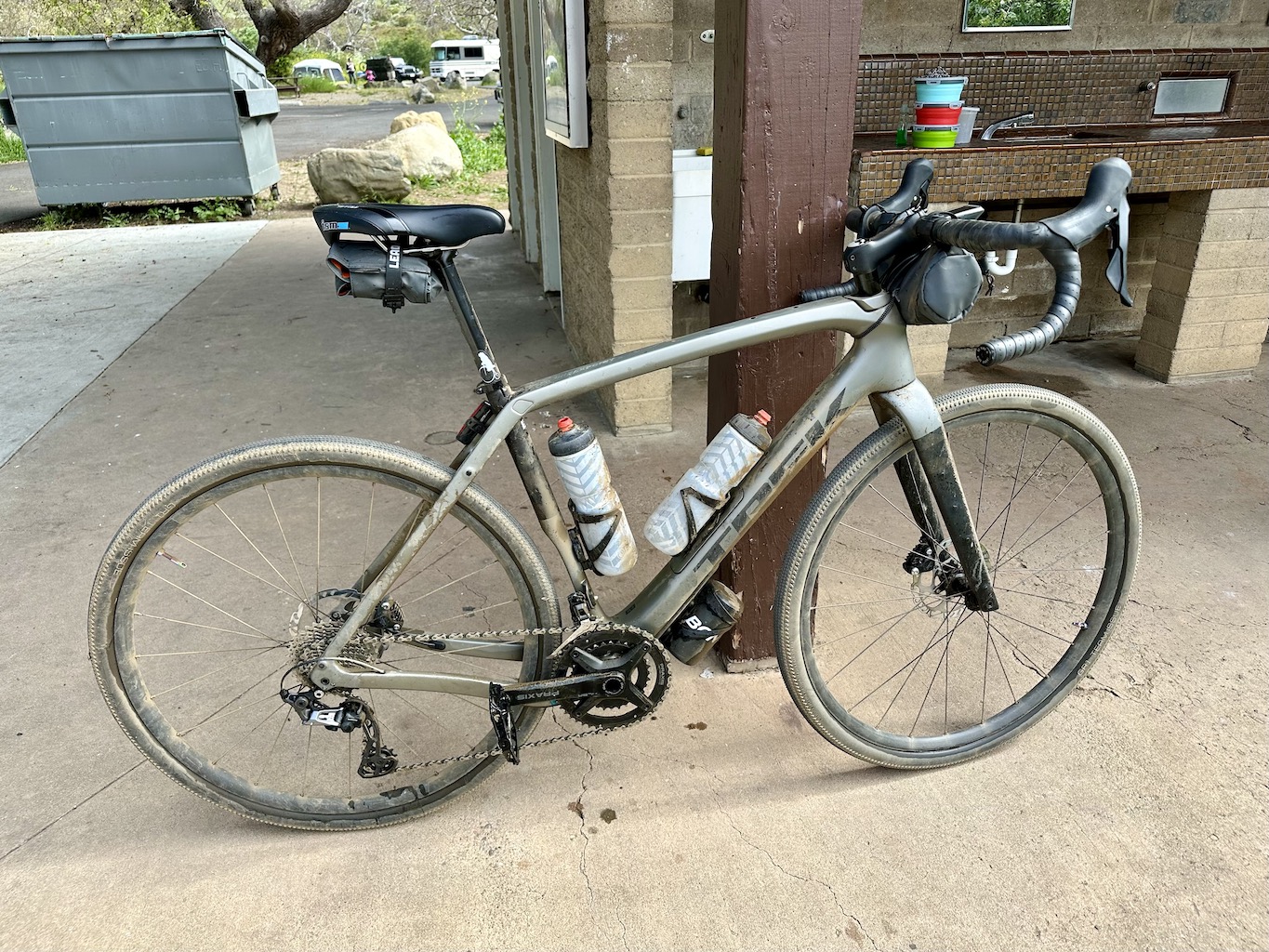 dirty gravel bike leaning against a campsite service building