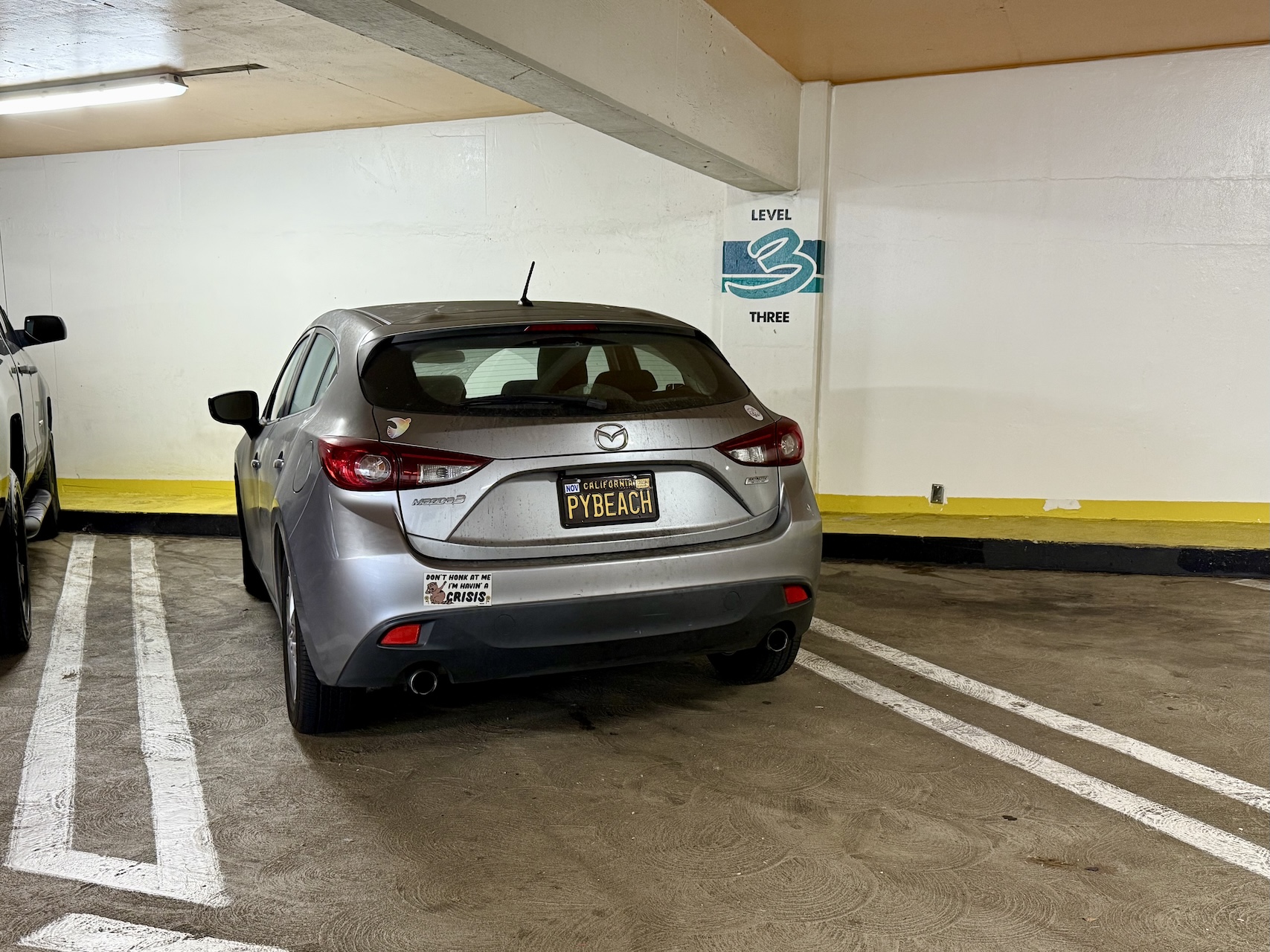 my silver 2014 Mazda3 hatchback with the PYBEACH license plate parked next to the PyBeach 2025 venue
