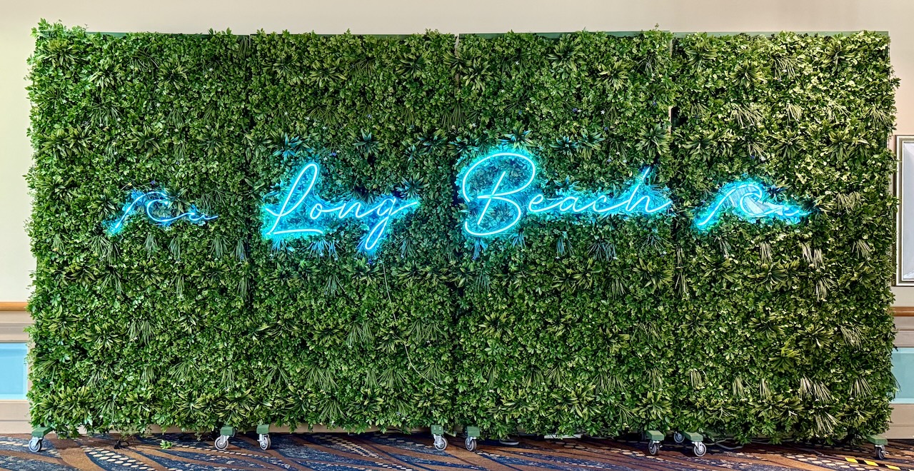 neon sign with waves and “Long Beach” on fake grass walls neon sign with waves and “Long Beach” on fake grass walls